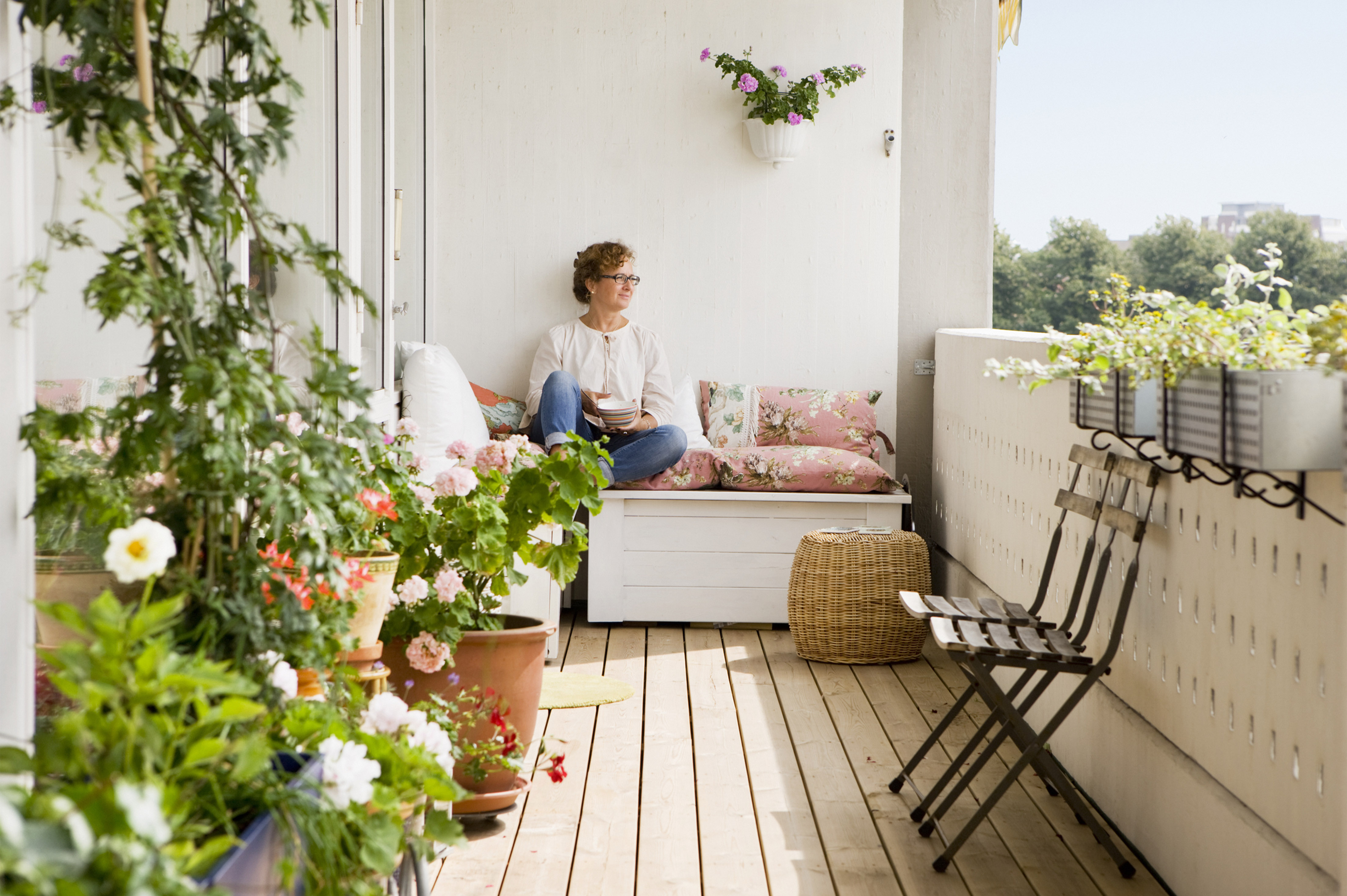 Kvinna dricker kaffe på balkong